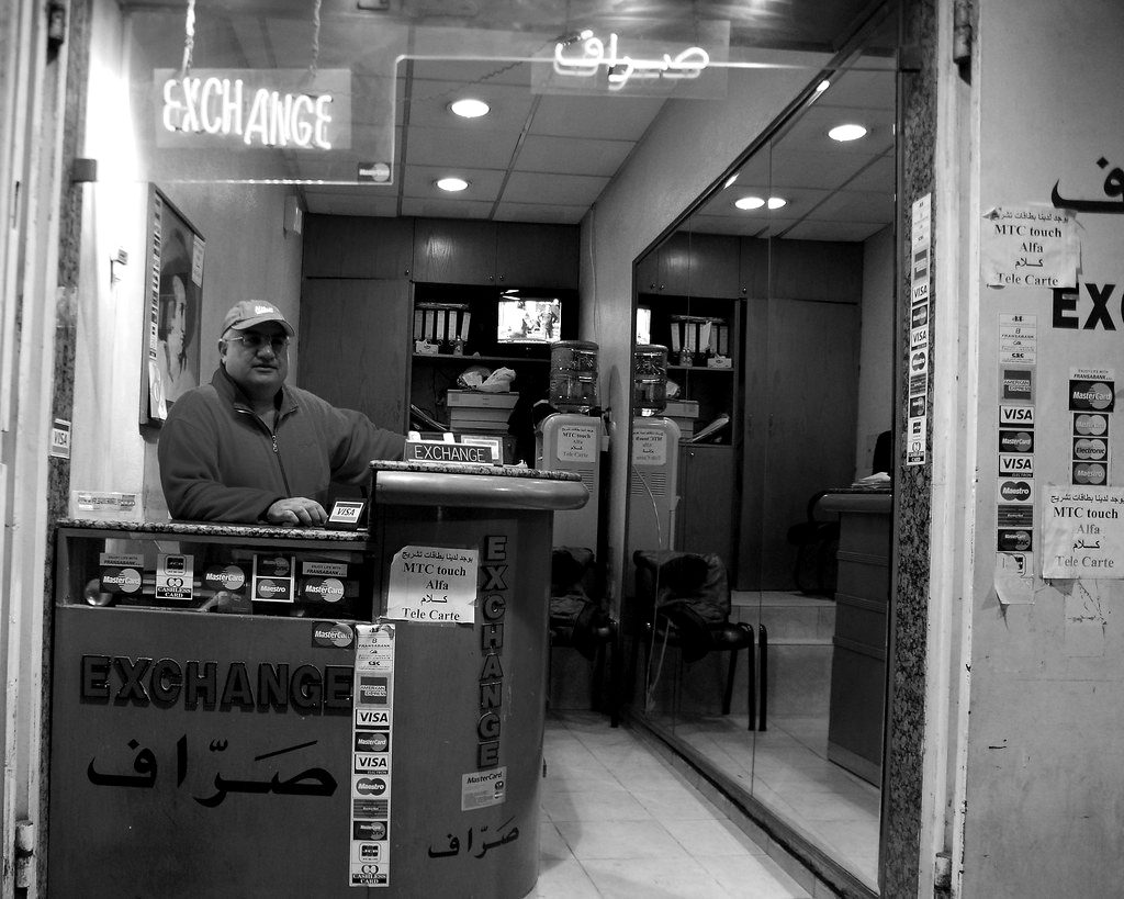 A currency exchange booth with a clerk behind the counter