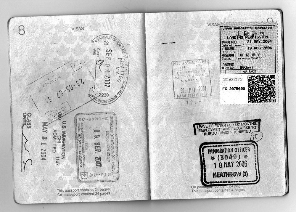 Open passport pages covered with entry and exit stamps