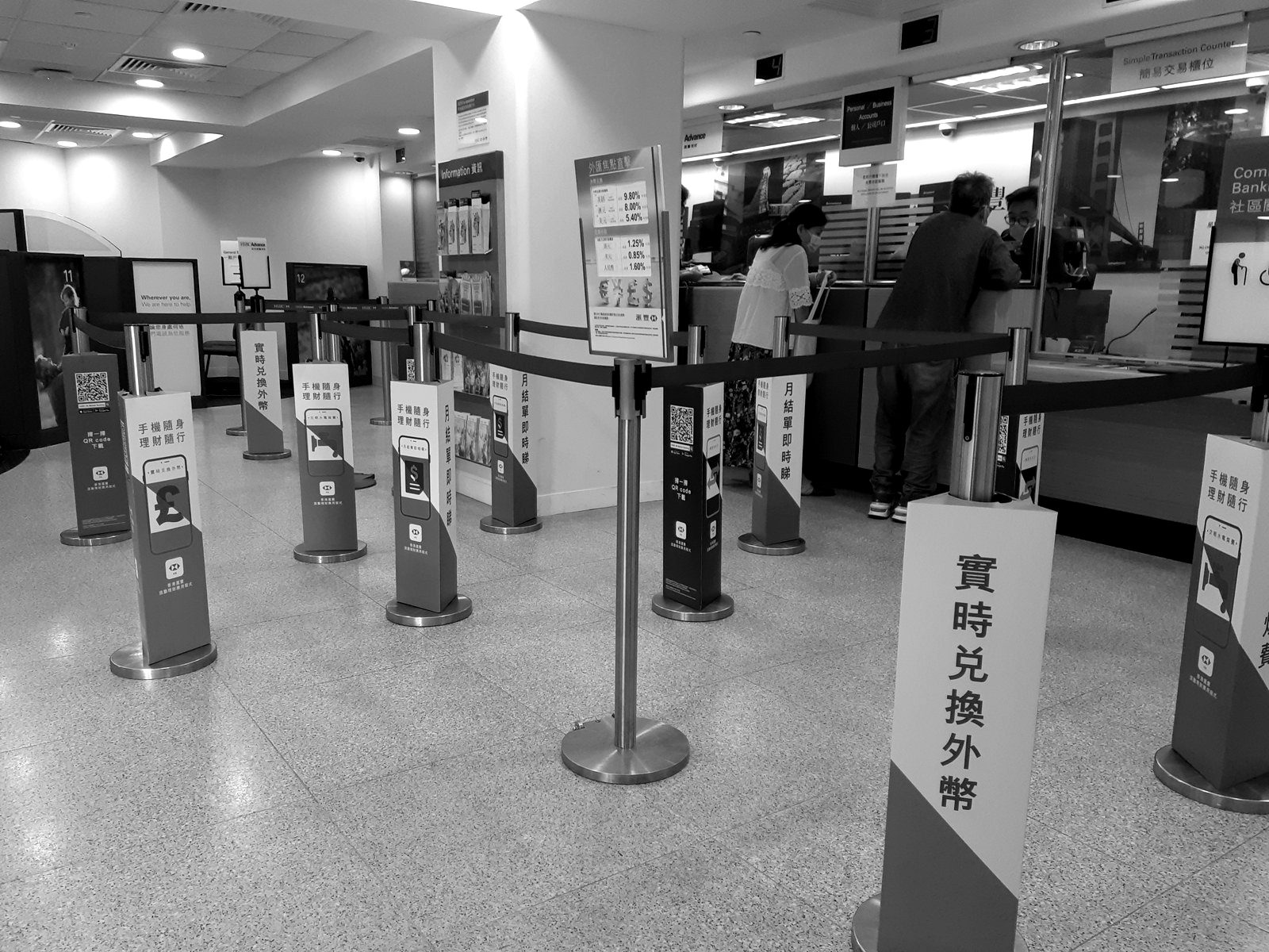 Self-service kiosks and queue barriers inside a bank branch