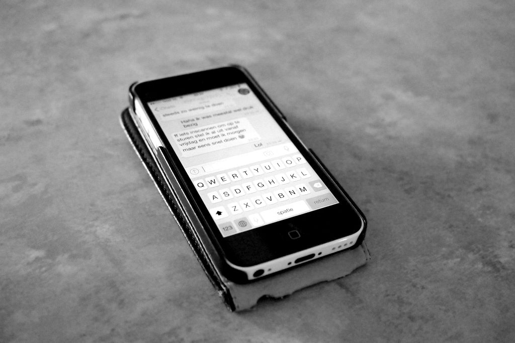 A smartphone on a grey surface showing a message