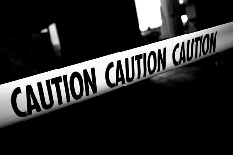 Yellow caution tape stretched across a dark background