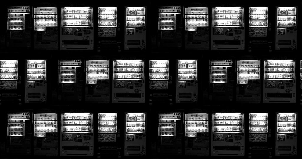Rows of brightly lit vending machines at night