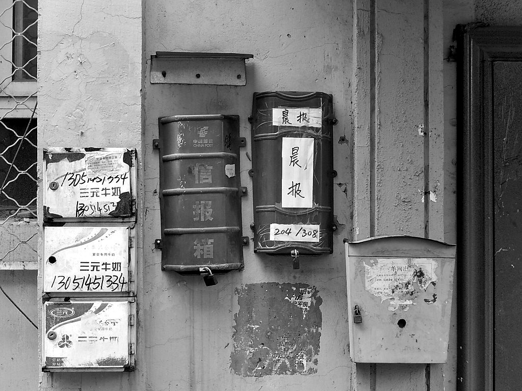 Mailboxes of different shapes fixed to a wall