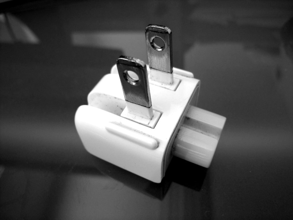 A white plug adapter with folding prongs