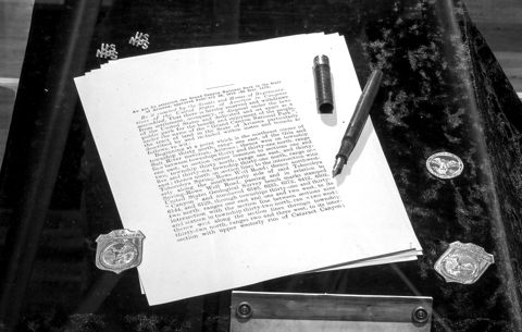 Typed pages and a fountain pen on a dark marble desk