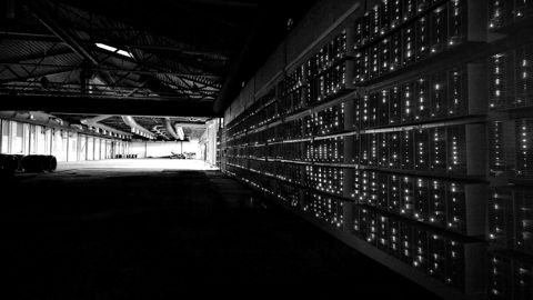 A long aisle of mining servers with green status lights