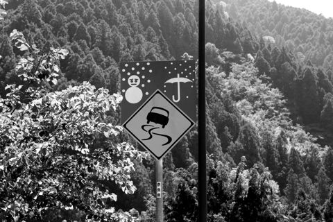 A slippery-road warning sign on a mountain road
