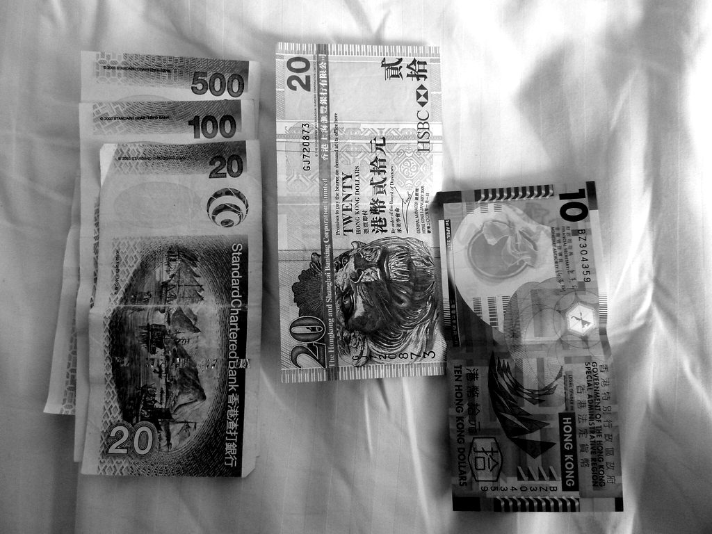 Banknotes from several currencies laid out on a white cloth