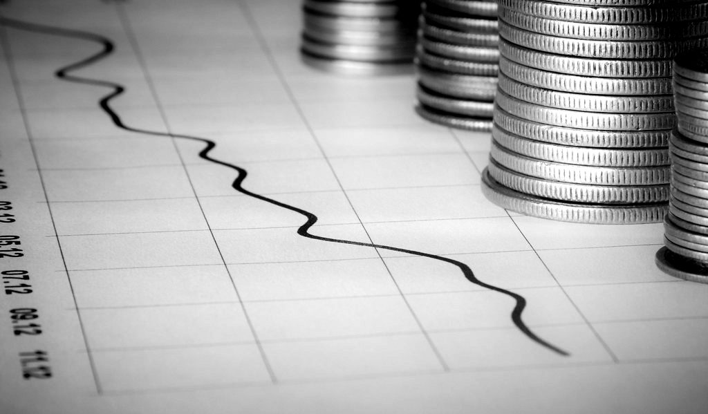 Stacks of coins beside a falling line chart