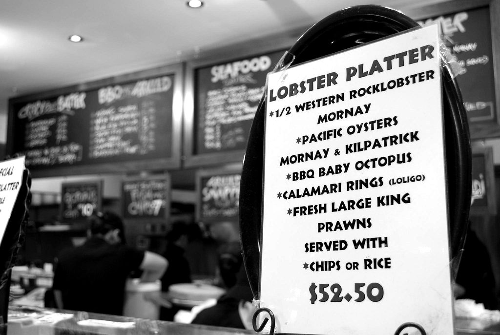 A seafood counter menu board listing prices
