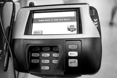A card payment terminal with keypad at a shop counter