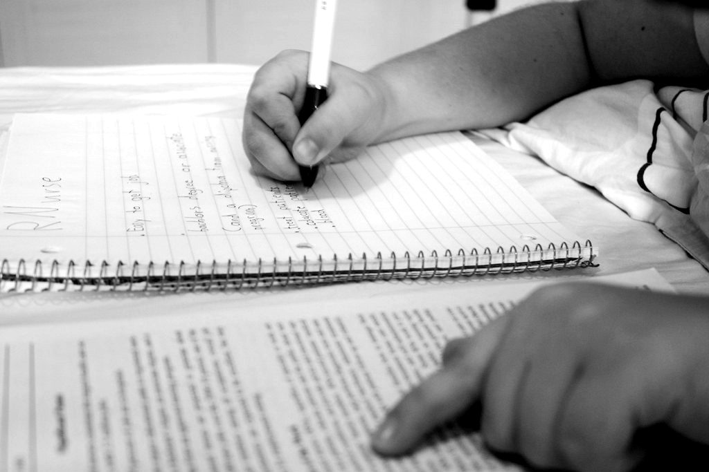 A hand following lines of printed text with a pen