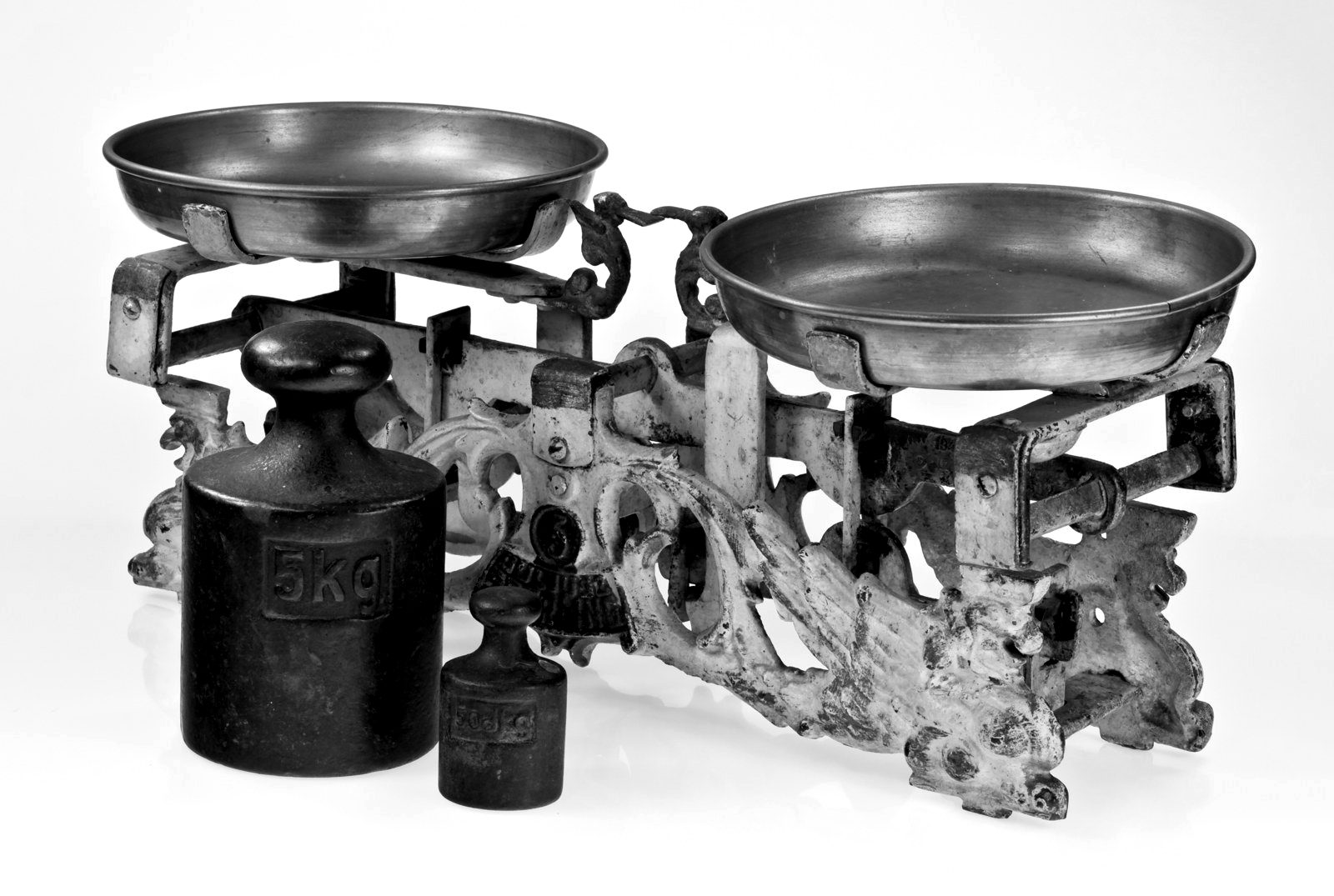 An antique brass balance scale with iron weights
