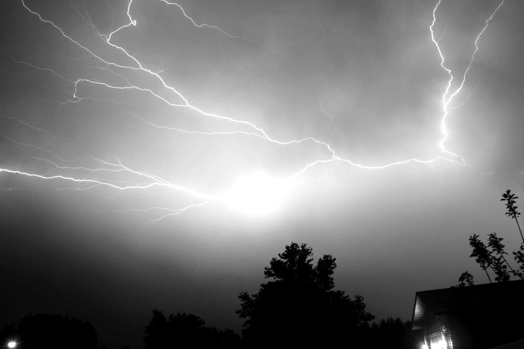 Branching lightning spreading across a violet night sky