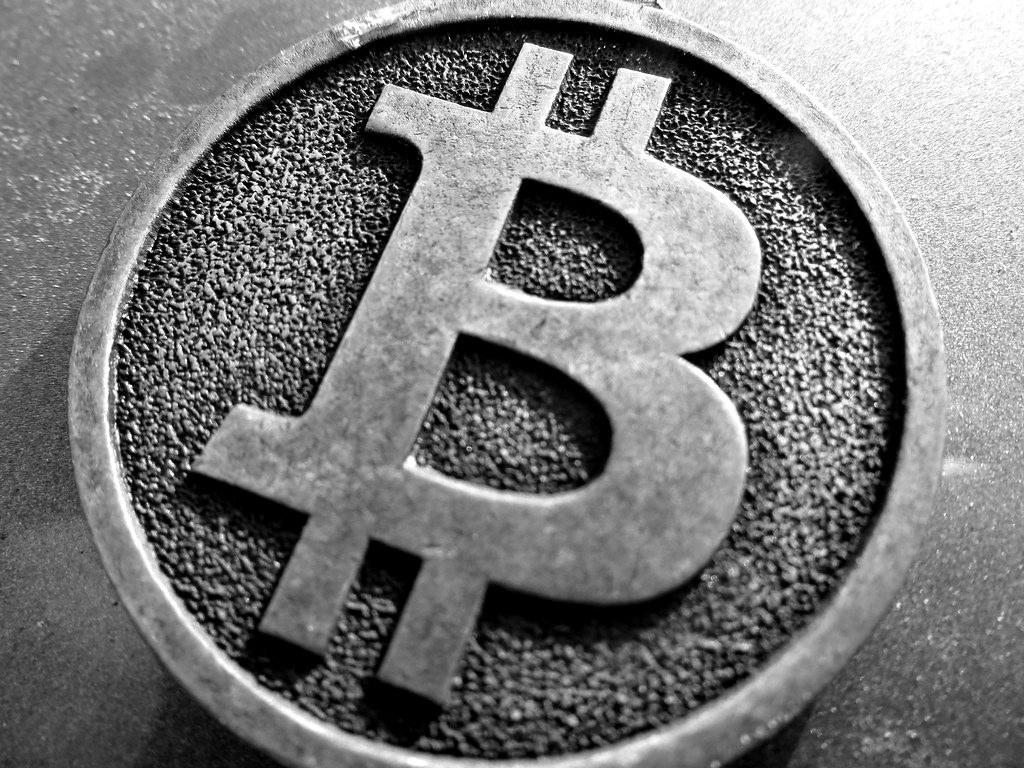 Close-up of an embossed Bitcoin symbol on a bronze-coloured coin