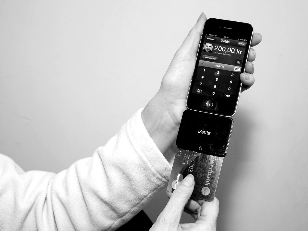 A card reader plugged into a smartphone taking a card payment