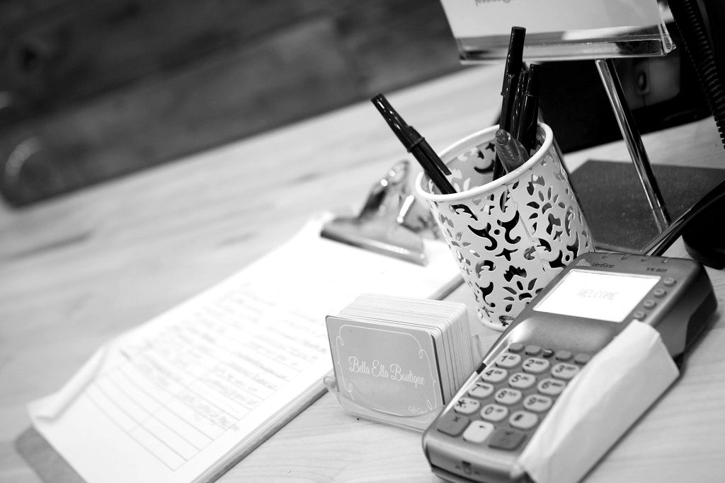 A card terminal on a café counter beside a receipt holder
