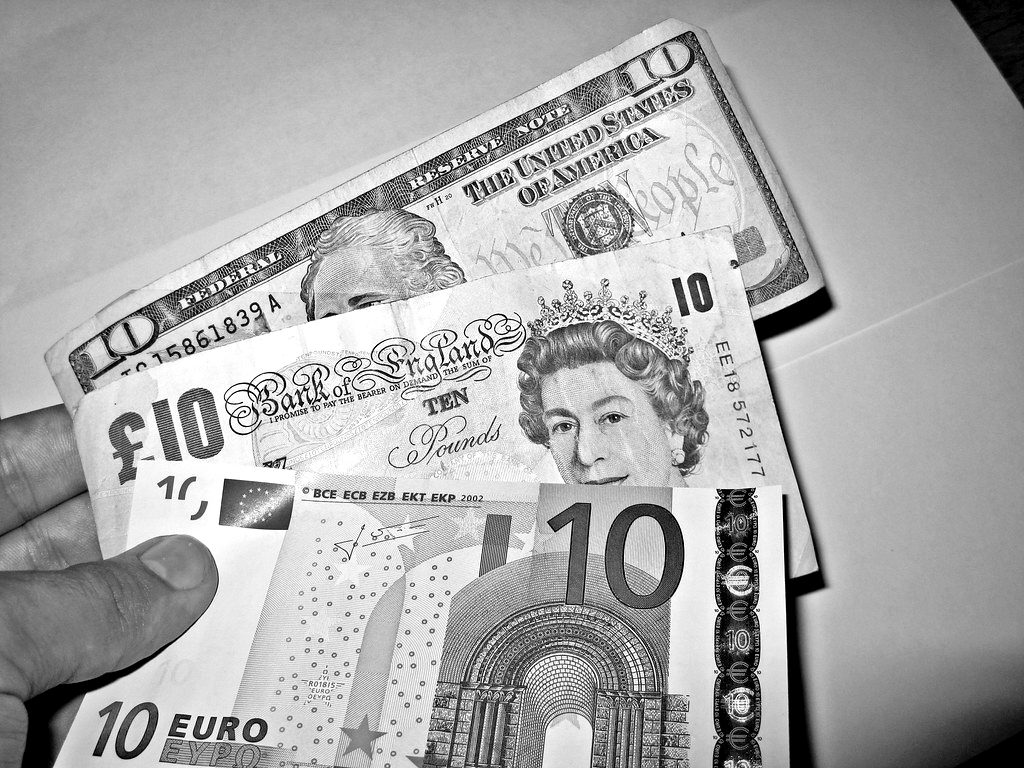 Dollar, pound and euro banknotes held in a hand